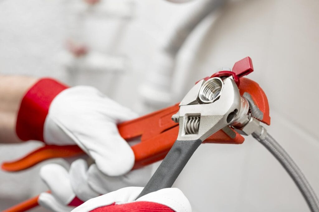 Plumber holding pipe wrenches for an emergency repair in Rancho Cucamonga