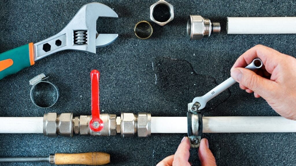 Plumber repairing a pipe valve with an adjustable wrench in Rancho Cucamonga