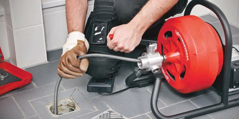 Plumber using a drain-cleaning machine in Rancho Cucamonga
